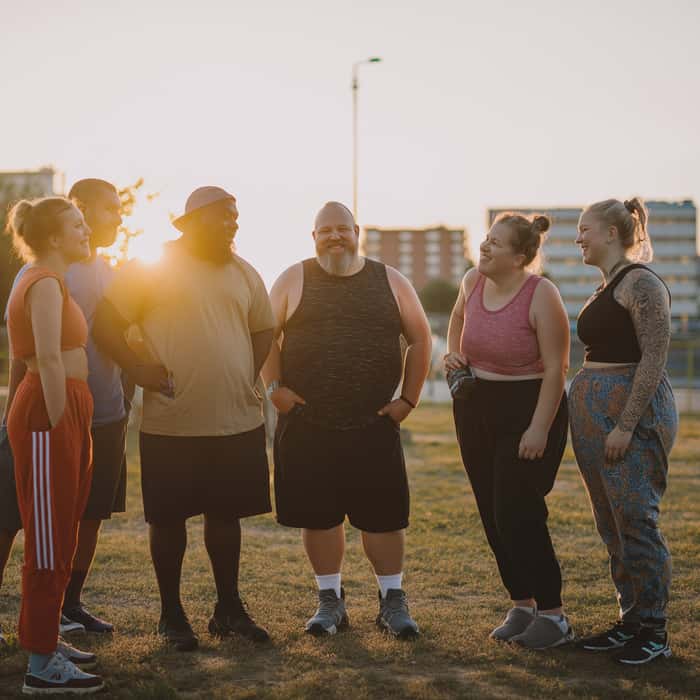 Group of people smiling after a weightloss focused workout.