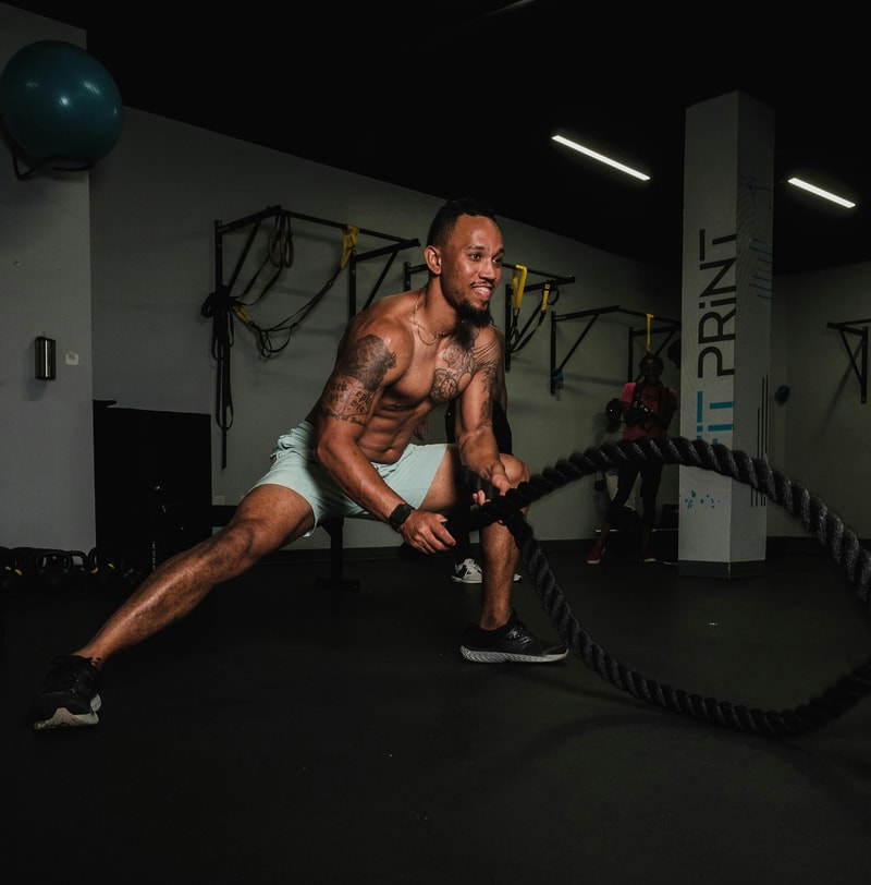 Man battling ropes as part of a performance training program.