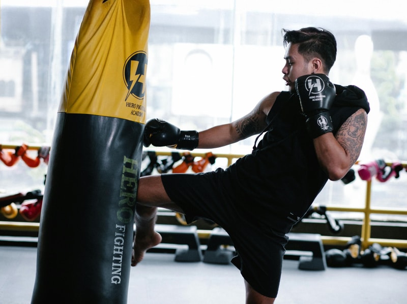 Man kicking a punching bag.